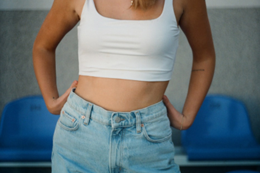An image of a woman wearing a white top and blue jeans